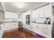 This modern kitchen features white cabinetry, stainless steel appliances, and warm hardwood floors at 500 Treasure Island Cswy # 308, Treasure Island, FL 33706