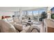 Open-concept living room with a large sectional sofa, balcony access, and a view of the water at 500 Treasure Island Cswy # 308, Treasure Island, FL 33706