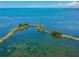 Gorgeous aerial view of a coastal area with boat trails on the clear water, and land with trees at 5915 Sea Ranch Dr # 703, Hudson, FL 34667