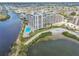 Breathtaking aerial view of a waterfront condo community with a sparkling pool, beach and lush landscaping at 5915 Sea Ranch Dr # 703, Hudson, FL 34667