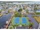 An aerial shot featuring tennis courts, a parking lot, docks and condo building at 5915 Sea Ranch Dr # 703, Hudson, FL 34667