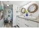 Bright bathroom with double sinks, granite countertops, and decorative round mirrors at 5915 Sea Ranch Dr # 703, Hudson, FL 34667