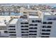 View of a condo building featuring patios and balconies with outdoor furniture and water in the background at 5915 Sea Ranch Dr # 703, Hudson, FL 34667