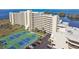 Condo building with tennis courts, lush landscaping, parking, and proximity to a body of water at 5915 Sea Ranch Dr # 703, Hudson, FL 34667
