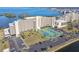 Condo building featuring tennis courts, lush landscaping, parking, and proximity to a body of water at 5915 Sea Ranch Dr # 703, Hudson, FL 34667