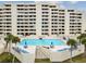 Inviting pool with ample lounge chairs and lush palm trees at 5915 Sea Ranch Dr # 703, Hudson, FL 34667