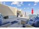 This roof top patio has beautiful outdoor furniture with a large lounging area and two outdoor dining tables at 5915 Sea Ranch Dr # 703, Hudson, FL 34667