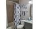 Charming bathroom featuring a stylish shower curtain, decorative flowers, and vanity mirror at 6421 Banyan Blvd # 302, New Port Richey, FL 34652