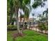 Inviting community pool area with lush landscaping and mature palm trees at 6421 Banyan Blvd # 302, New Port Richey, FL 34652