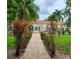Gated community pool with a brick-paved walkway through lush greenery, offering a relaxing escape at 6421 Banyan Blvd # 302, New Port Richey, FL 34652