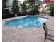 Community pool with brick patio, offering a refreshing escape and relaxing atmosphere at 6421 Banyan Blvd # 302, New Port Richey, FL 34652