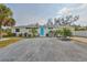 Street view of a well-maintained single-story home featuring a blue front door and a spacious driveway at 6560 5Th S Ave, St Petersburg, FL 33707