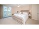 Bright primary bedroom featuring a tufted headboard, access to balcony, and water views at 690 Island Way # 404, Clearwater Beach, FL 33767