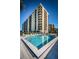 Building exterior with a beautiful waterfront pool, lounge chairs, and manicured landscaping at 690 Island Way # 404, Clearwater Beach, FL 33767