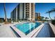 Relaxing pool area with lounge chairs surrounded by well-maintained condos and tropical landscaping at 690 Island Way # 404, Clearwater Beach, FL 33767