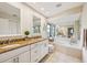 Bright bathroom with a double vanity, granite countertops, and separate tub with tile surround at 7245 Wood Creek Dr # 29, Sarasota, FL 34231