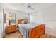 Cozy bedroom with a wood-framed bed, a nightstand with a lamp, and natural light from the window at 7245 Wood Creek Dr # 29, Sarasota, FL 34231