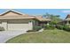 Charming one-story home with a well-maintained lawn, beige exterior, and an attached two-car garage at 7245 Wood Creek Dr # 29, Sarasota, FL 34231