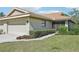 Attractive exterior of a one-story beige home with a two-car garage and lush green lawn at 7245 Wood Creek Dr # 29, Sarasota, FL 34231