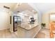 Bright kitchen featuring an island with granite countertop, white cabinets, and stainless steel refrigerator at 7245 Wood Creek Dr # 29, Sarasota, FL 34231