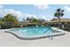Community pool featuring palm trees, fences, and lounge chairs at 7245 Wood Creek Dr # 29, Sarasota, FL 34231