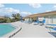 Relaxing poolside featuring blue lounge chairs and a view of the community buildings at 7245 Wood Creek Dr # 29, Sarasota, FL 34231