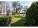 Lush backyard with green grass, mature landscaping, and a serene view of the lake at 732 June Lake Ln, Brandon, FL 33510