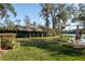 Expansive backyard offers lush greenery, mature trees, a cozy hammock, and serene lake views at 732 June Lake Ln, Brandon, FL 33510