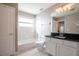 Bright bathroom with white cabinets, black granite countertop, and a shower over the tub at 732 June Lake Ln, Brandon, FL 33510
