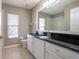 Bathroom with black countertops, tiled floors, and a large mirror with great lighting at 732 June Lake Ln, Brandon, FL 33510