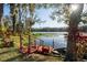 Picturesque lake view with a private wooden dock, lush landscaping, and a small boat at 732 June Lake Ln, Brandon, FL 33510