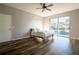 Sunlit main bedroom boasts sleek wood floors, a neutral color palette, and sliding glass doors to the pool at 732 June Lake Ln, Brandon, FL 33510