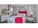 Stylish bedroom with flamingo art, modern white dressers and accents, and colorful pink bedding at 8621 Snowfall St, Sarasota, FL 34241