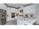 Modern kitchen with stainless steel appliances, granite countertops, and white cabinetry at 8621 Snowfall St, Sarasota, FL 34241