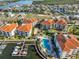 Aerial view of condo complex with marina and neighborhood, featuring waterway views, lush landscaping, and community pool at 1030 Bellasol Way # 302, Apollo Beach, FL 33572