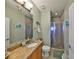 Well-lit bathroom featuring a shower with glass door, decorative tiles and a vanity with granite countertops at 1030 Bellasol Way # 302, Apollo Beach, FL 33572