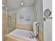 Bathroom with a tiled shower and a large soaking tub at 1030 Bellasol Way # 302, Apollo Beach, FL 33572