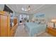Bright main bedroom with a ceiling fan, balcony access, and views of the outdoors at 1030 Bellasol Way # 302, Apollo Beach, FL 33572