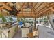 Outdoor tiki bar with a thatched roof, ceiling fan, mounted speakers and TV, plus seating for community residents at 1030 Bellasol Way # 302, Apollo Beach, FL 33572