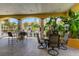 Outdoor grilling area with tables and chairs for entertaining, set amidst tropical foliage at 10764 70Th Ave # 2110, Seminole, FL 33772