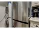 Stainless steel refrigerator and stacked washer dryer adjacent to stainless coffee maker at 10764 70Th Ave # 2110, Seminole, FL 33772