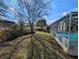 Expansive backyard featuring a screened-in pool, mature trees, and partial brick retaining wall at 11040 Flicker Rd, Brooksville, FL 34613