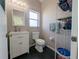 A cozy bathroom with a single sink, storage shelf and a window providing natural light at 11040 Flicker Rd, Brooksville, FL 34613