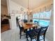 Dining area features a chandelier, and a view of the pool and back yard through the sliding glass doors at 11040 Flicker Rd, Brooksville, FL 34613