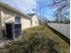 Exterior view of house featuring a vinyl fence, AC unit, and a lush lawn at 11040 Flicker Rd, Brooksville, FL 34613