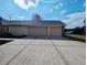 Exterior view of the house showcasing a two-car garage and long driveway at 11040 Flicker Rd, Brooksville, FL 34613