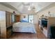 Large main bedroom with tray ceilings, ceiling fan, hardwood floors and ensuite bathroom at 11040 Flicker Rd, Brooksville, FL 34613