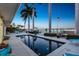 Back patio with a lovely swimming pool, lounge chairs, palm trees, and a channel view at 11385 9Th E St, Treasure Island, FL 33706