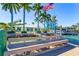 Exterior water view includes dock, boat lift, palm trees and bench seating at 11385 9Th E St, Treasure Island, FL 33706