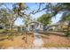 Quaint single-story home with mature trees and a inviting walkway at 1212 E New Orleans Ave, Tampa, FL 33603